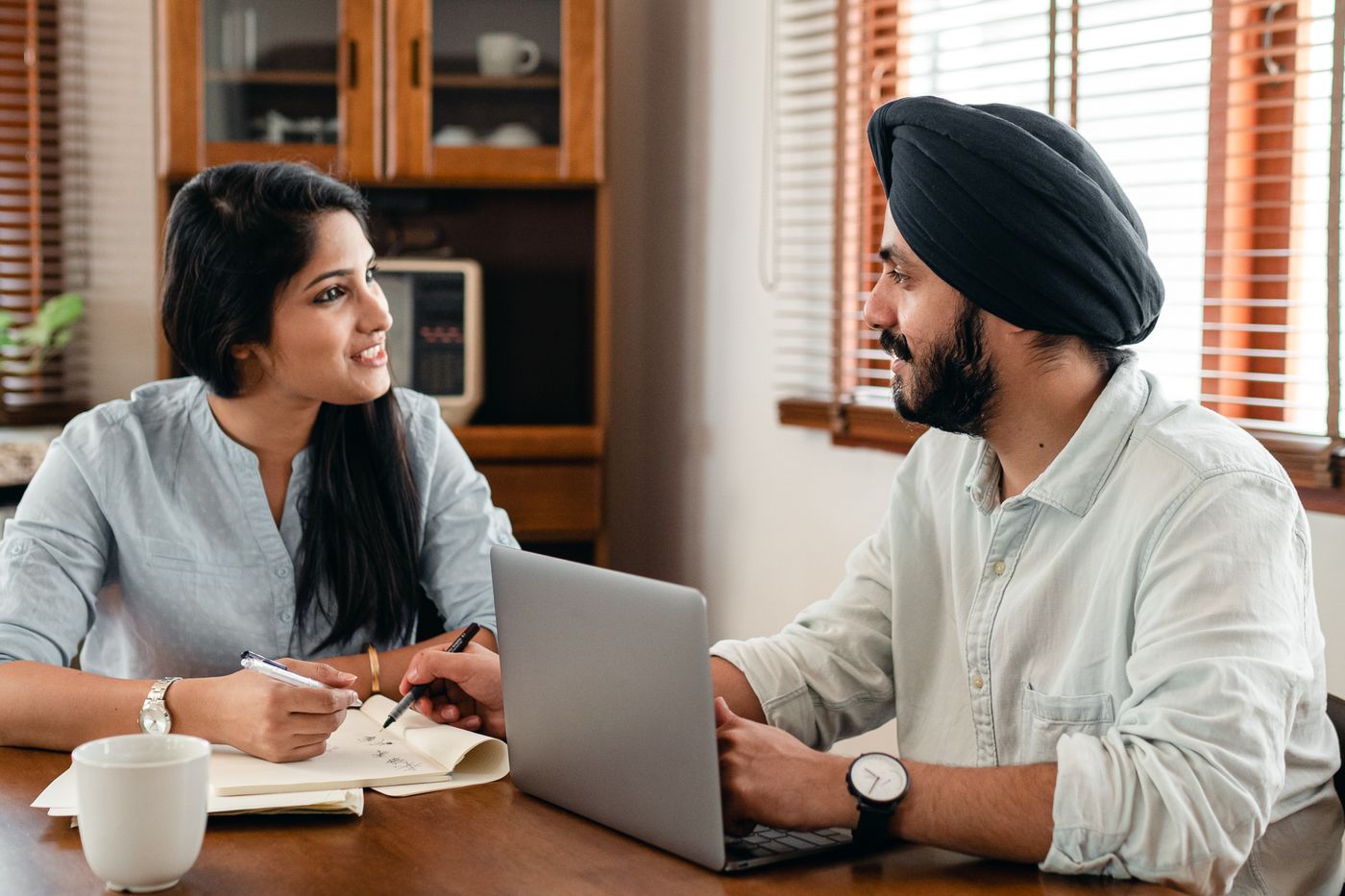 Two colleagues reviewing work together on a laptop