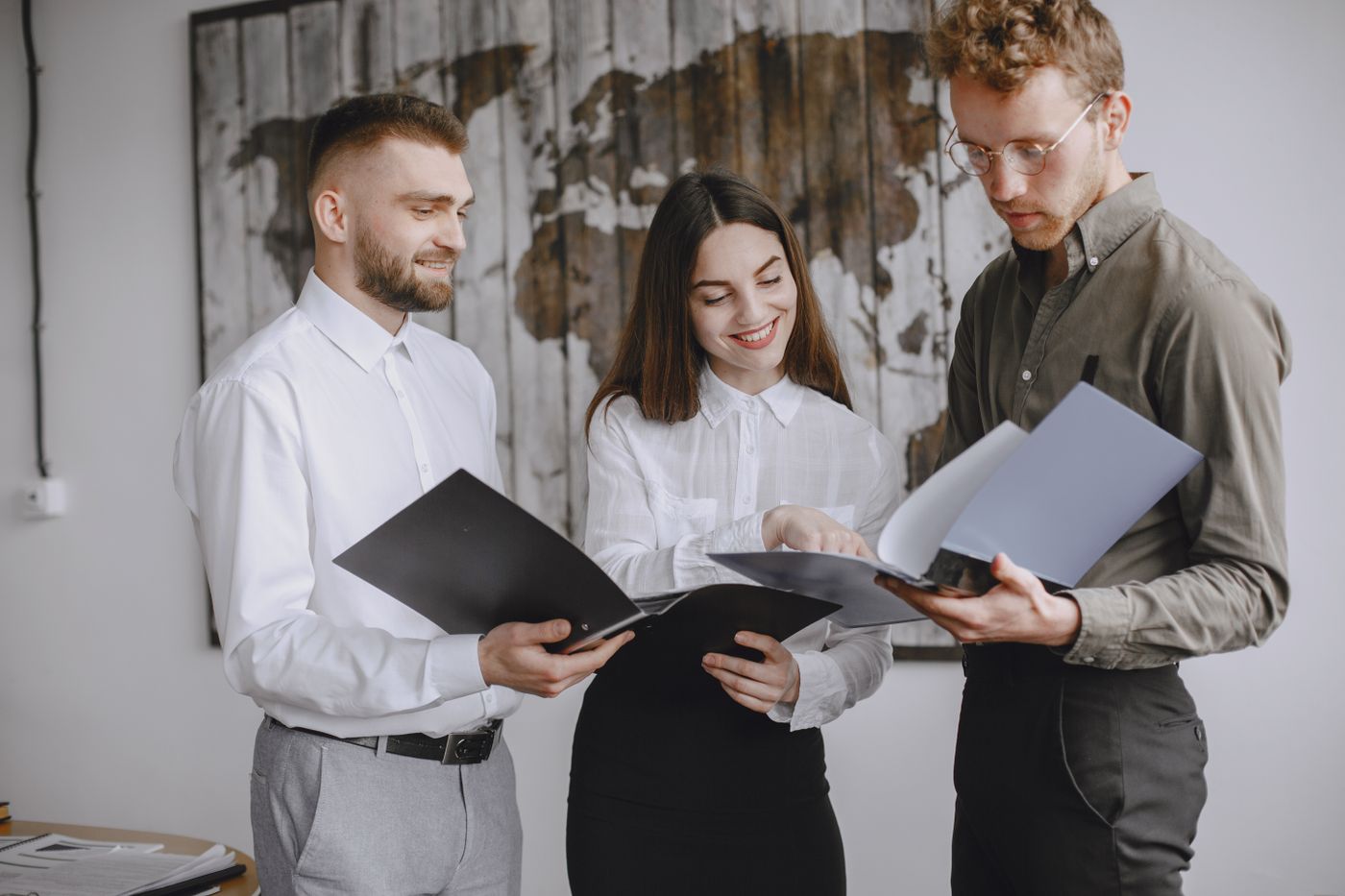 Three colleagues reviewing recruitment documents together in an office