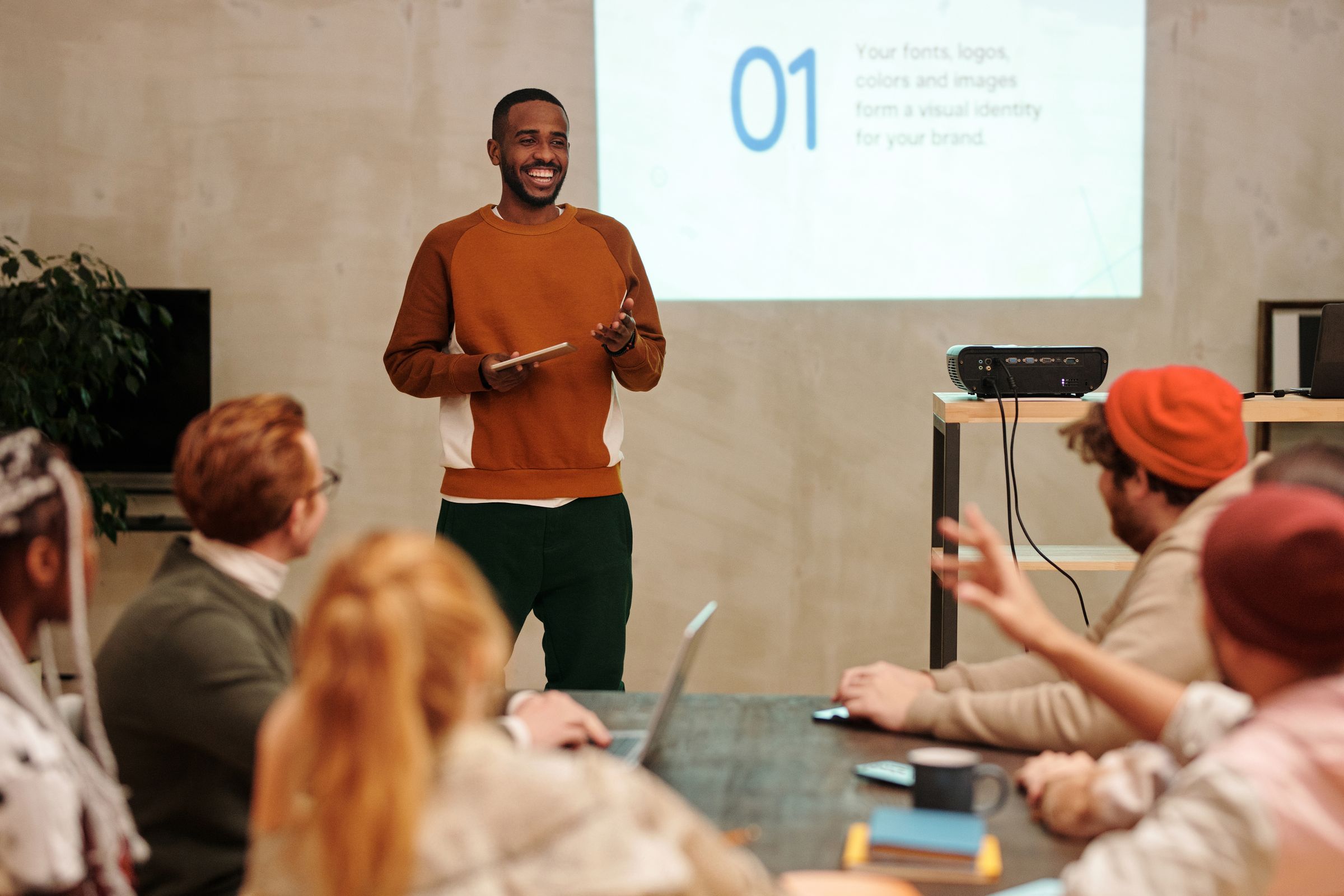 Presenter leading a workshop for colleagues gathered around a meeting table