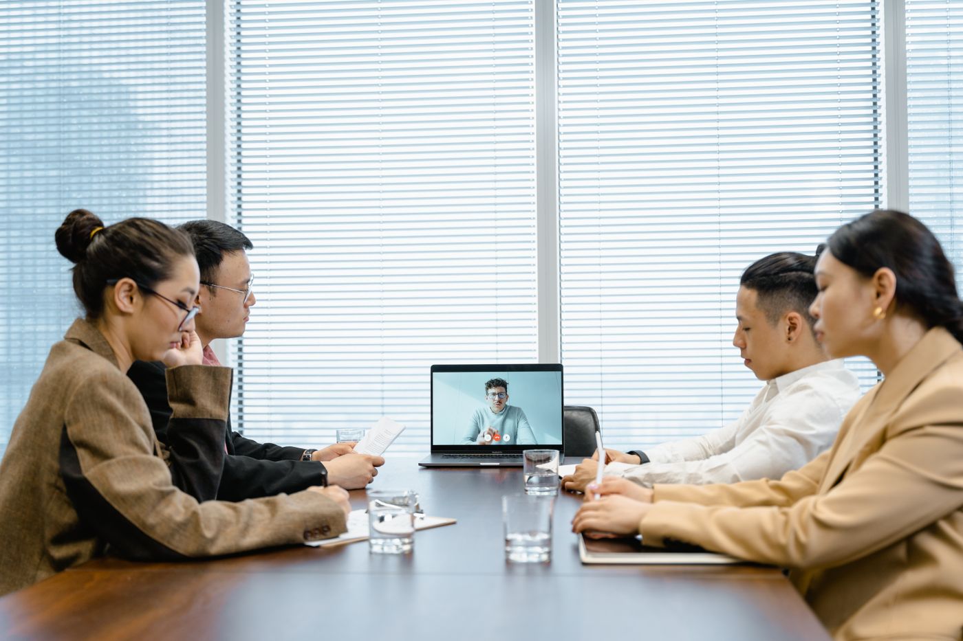 Team on a video call with a remote colleague in a meeting room