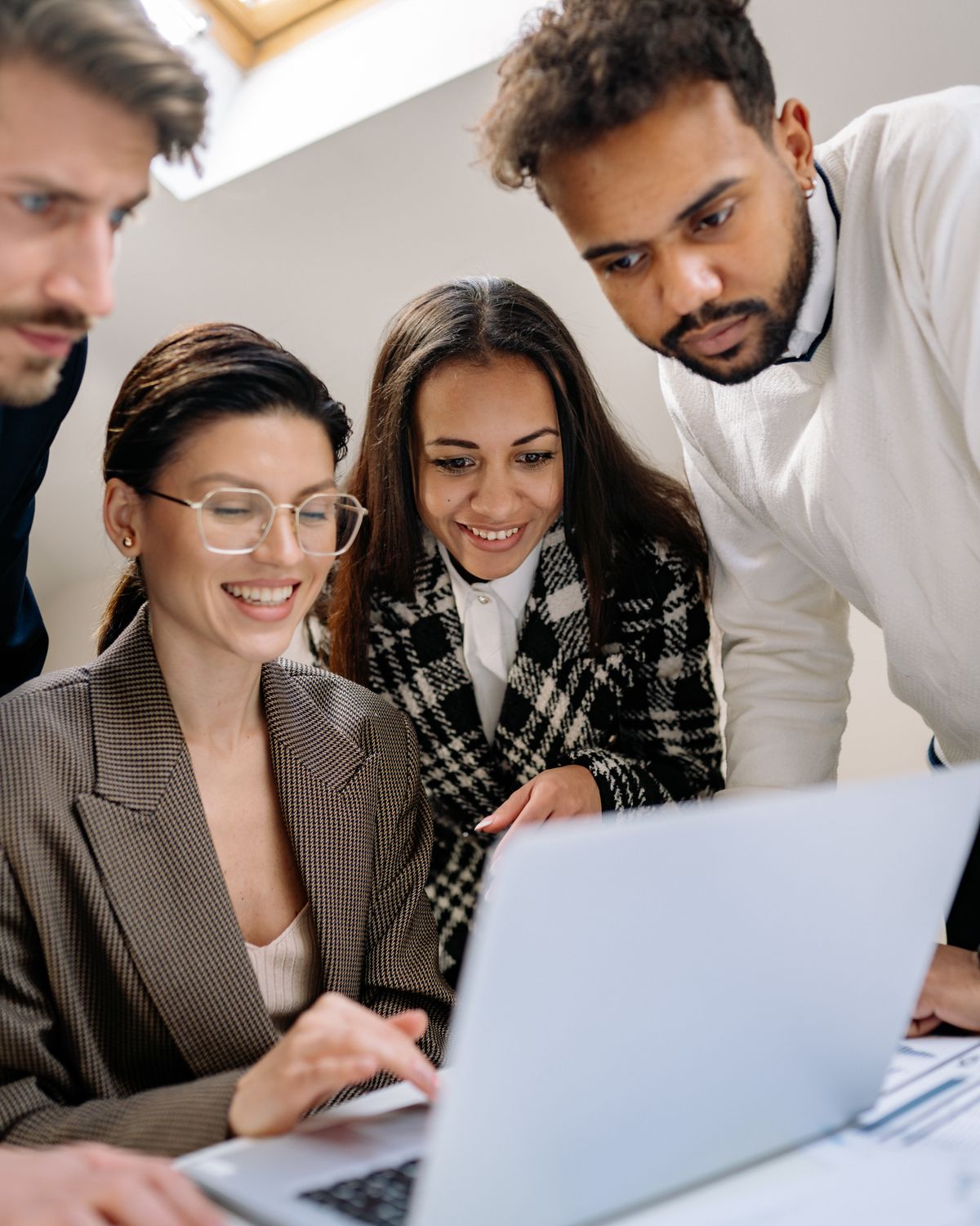 Colleagues reviewing work together around a laptop