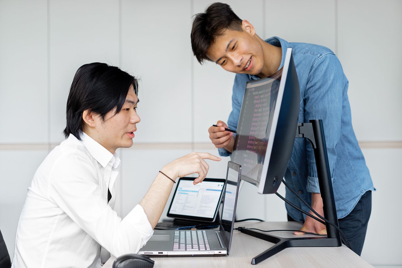 Two engineers connecting systems at their monitors