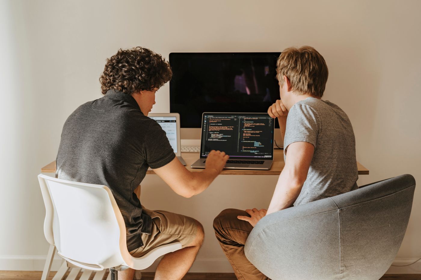 Two developers integrating applications on their laptops