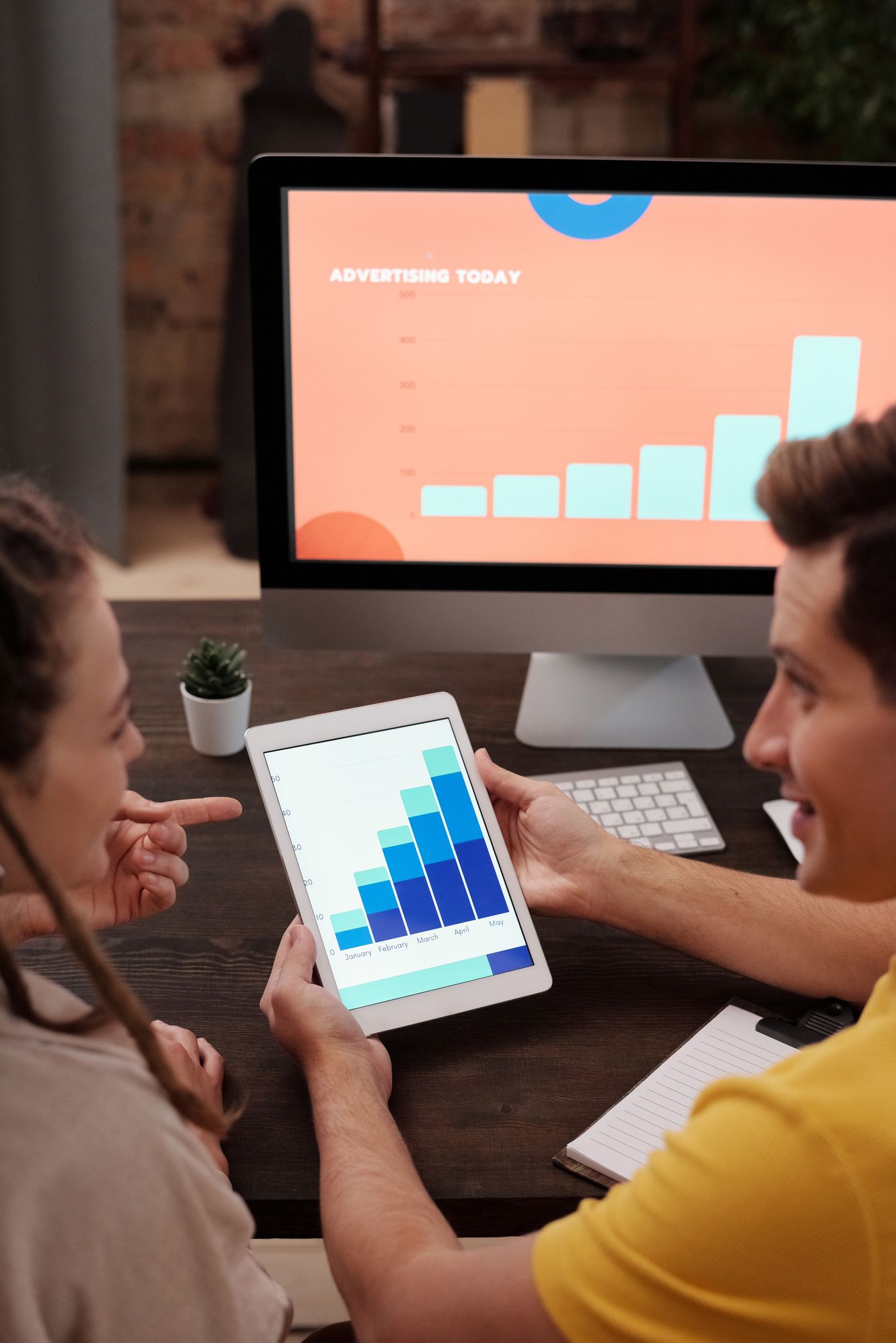 Two colleagues reviewing campaign spend on a tablet