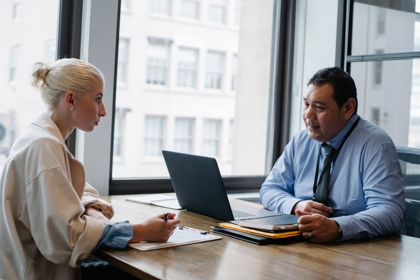 Hiring manager interviewing a candidate who is filling in an application form