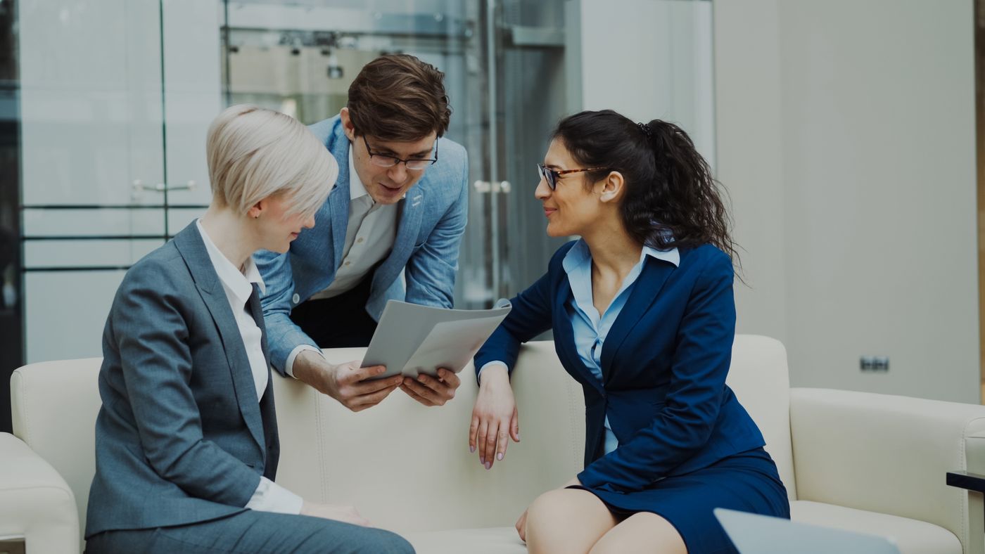Three consultants reviewing a solution plan together on a tablet
