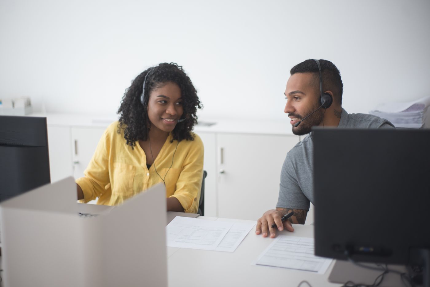 Two revenue colleagues on headsets working in the CRM