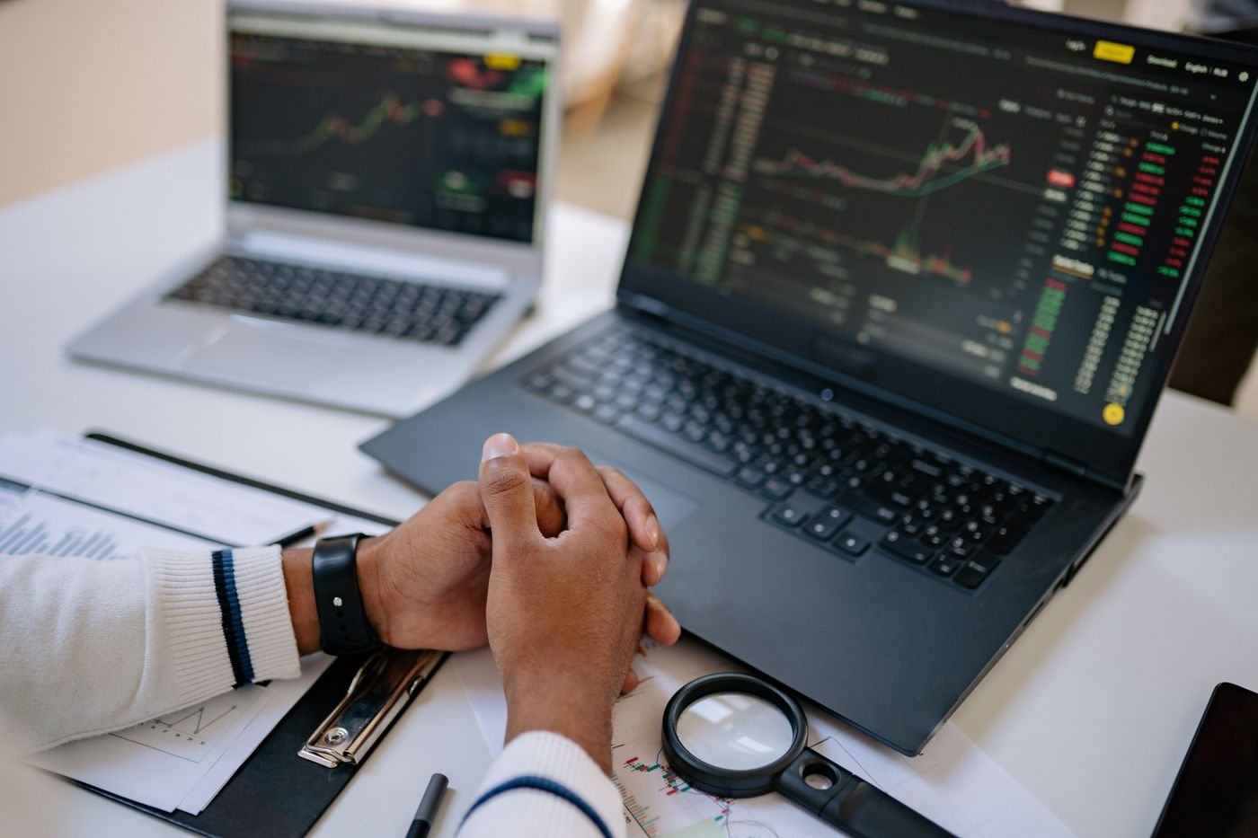 Analyst reviewing transaction data across laptop screens