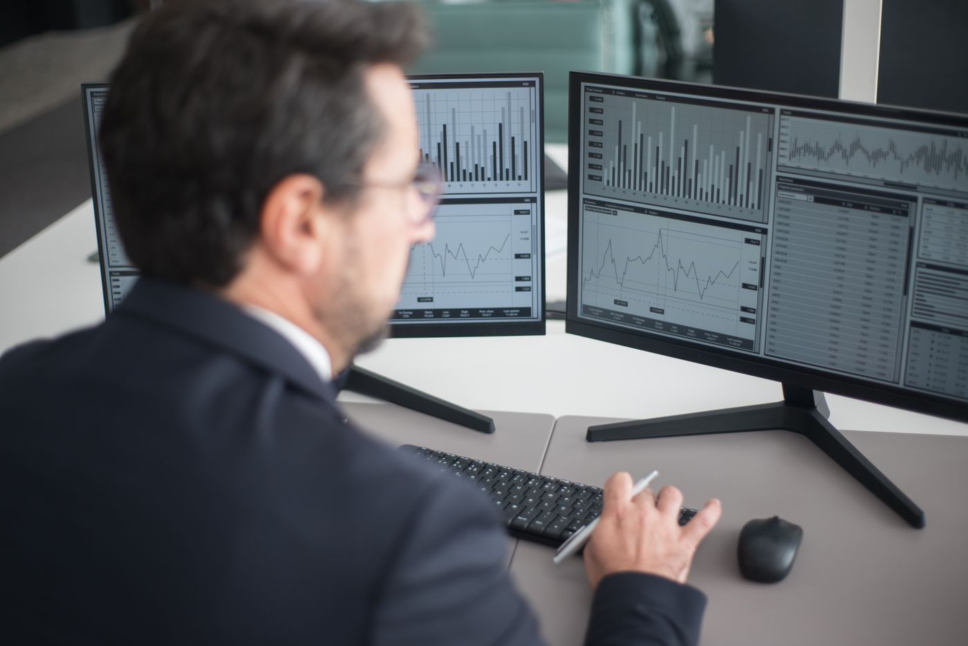 Analyst monitoring data flows across two screens