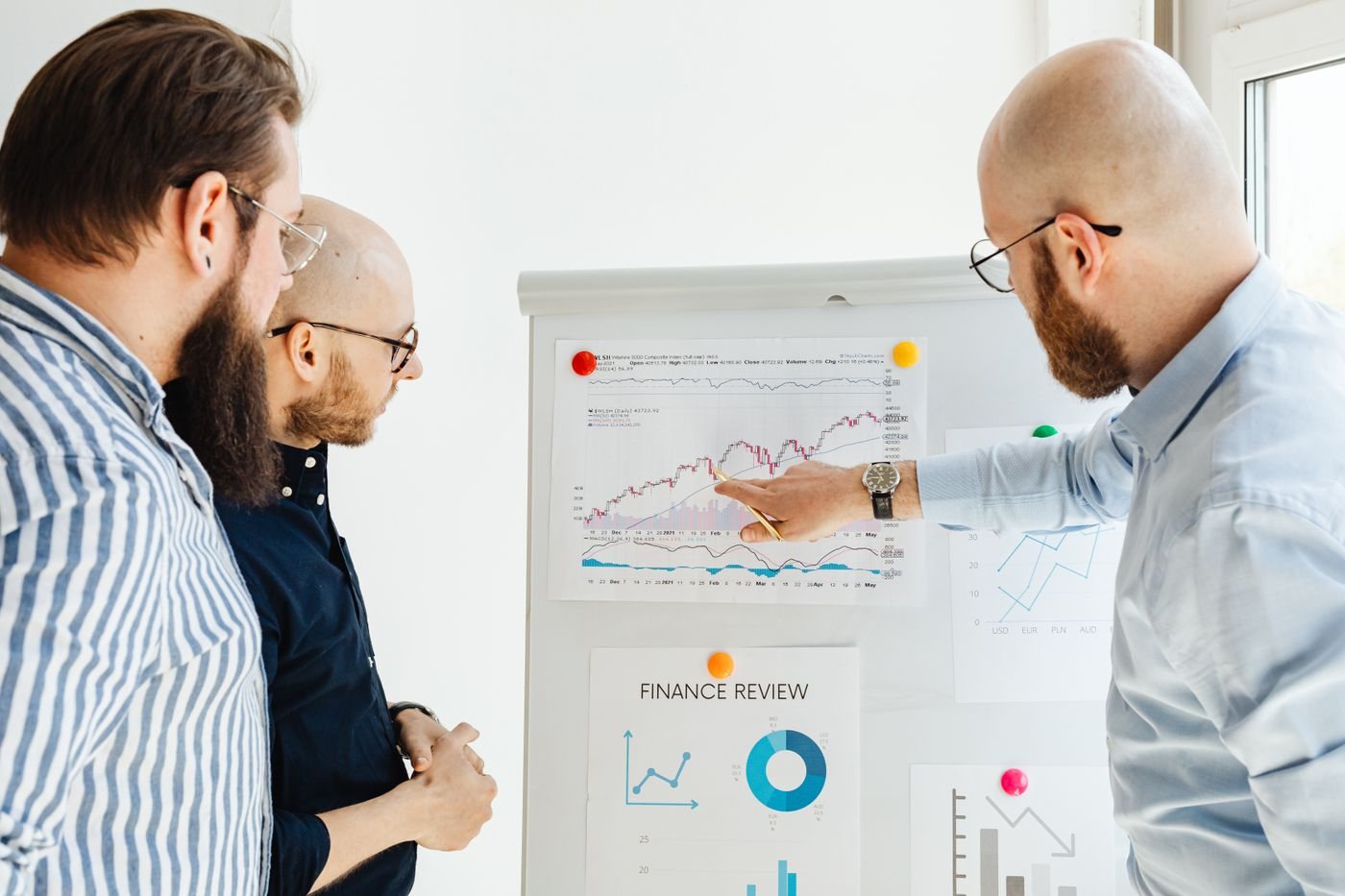 Sales leaders reviewing pipeline and forecast charts on a whiteboard