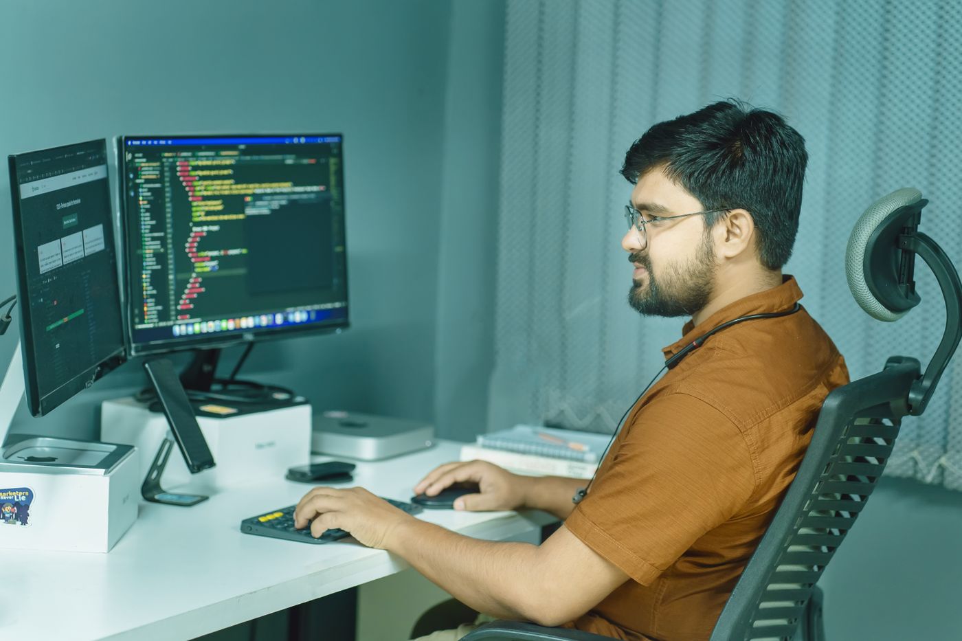 Developer configuring application code across two monitors