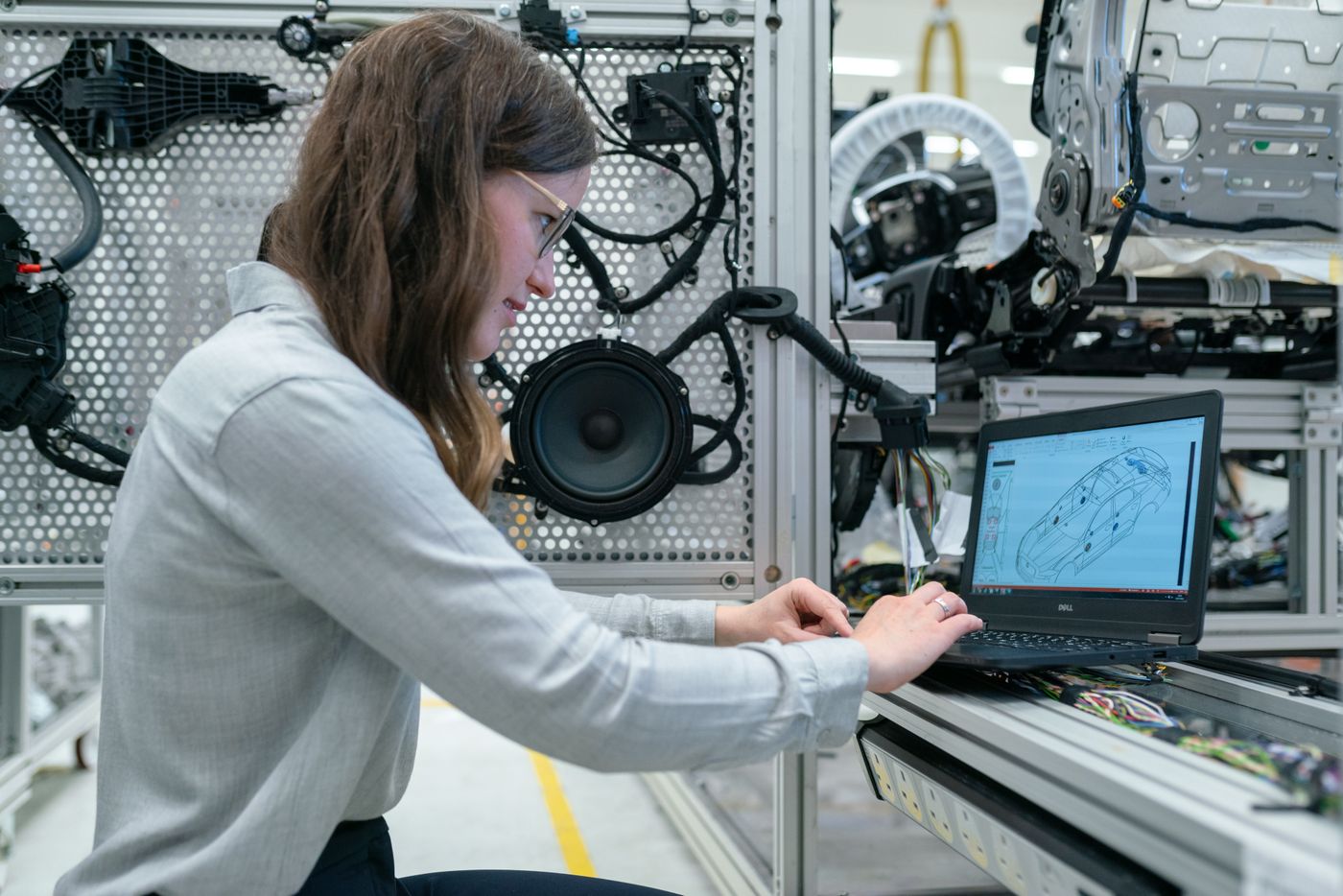 Engineer configuring an application on a laptop beside production equipment