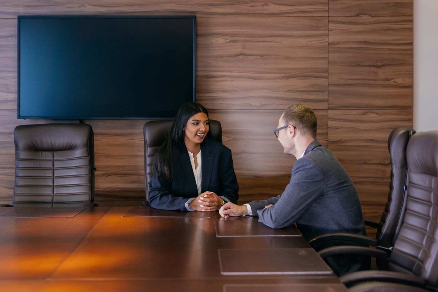 Candidate and interviewer in conversation across a boardroom table