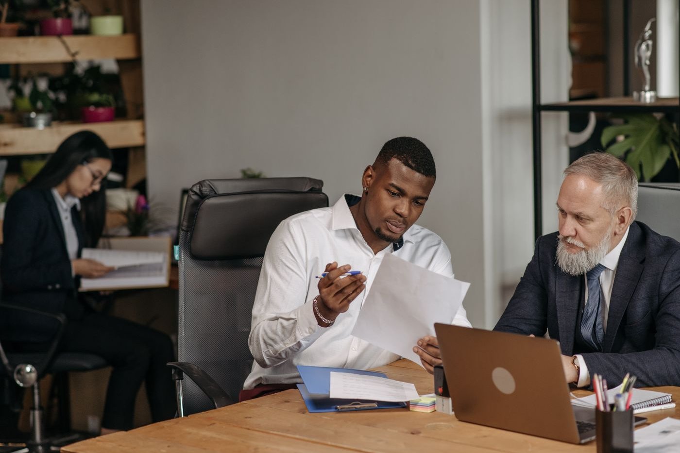 Team working through documents and a laptop together at an office desk