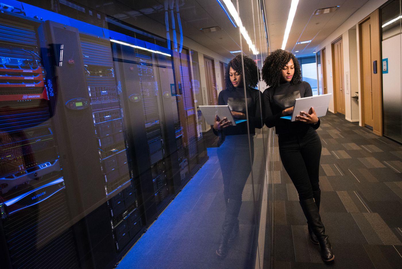 Engineer with a laptop walking through a data centre