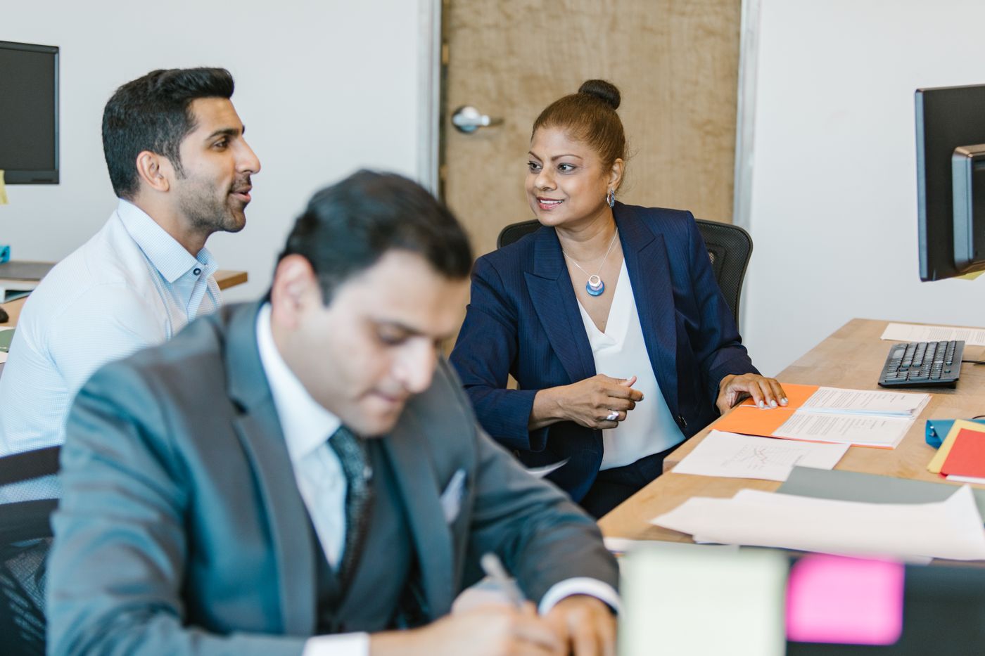 Colleagues working through documents together at their desks