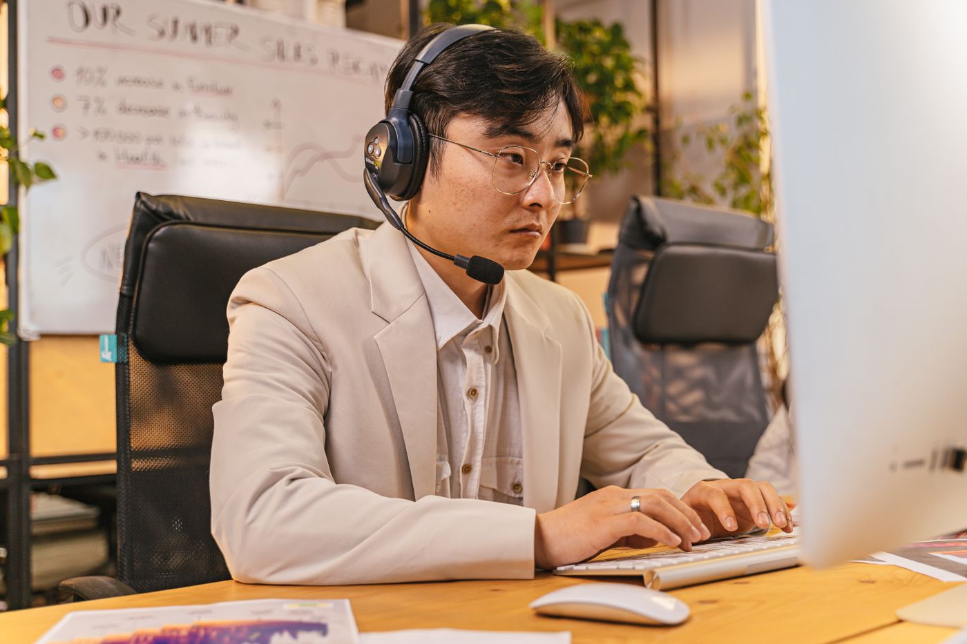 Sales rep working prospects on a headset at his desk