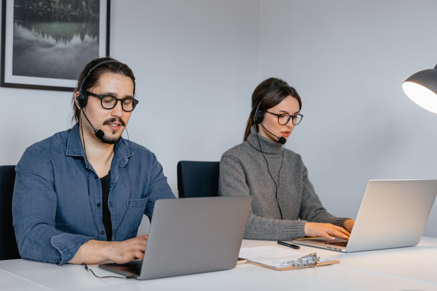 Support engineers with headsets working at their laptops