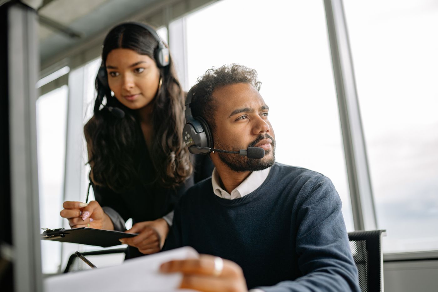 Two support engineers with headsets working through a request together