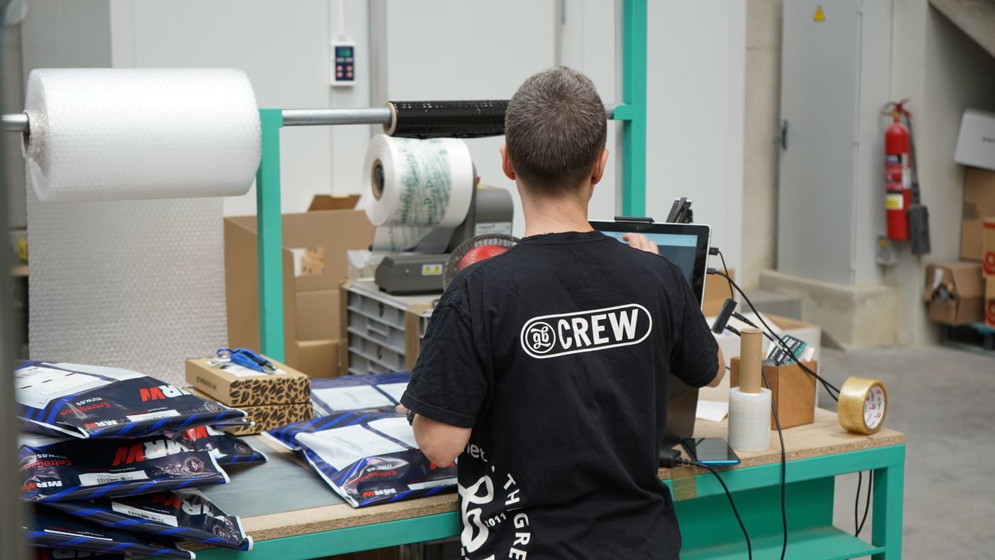Operations worker processing orders at a computer in a warehouse