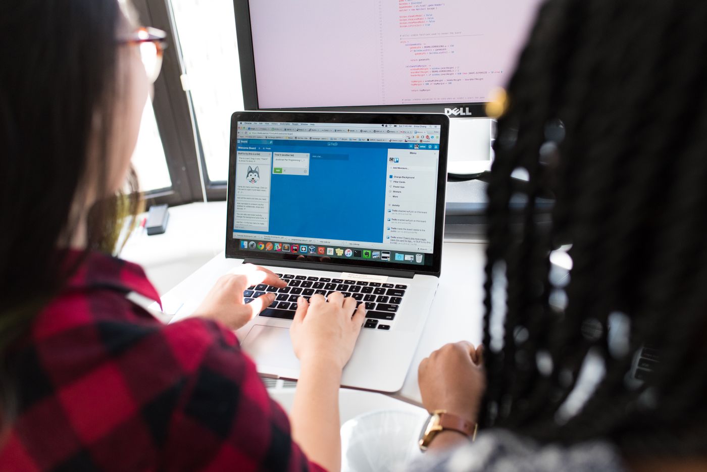 Two colleagues connecting business tools on a laptop