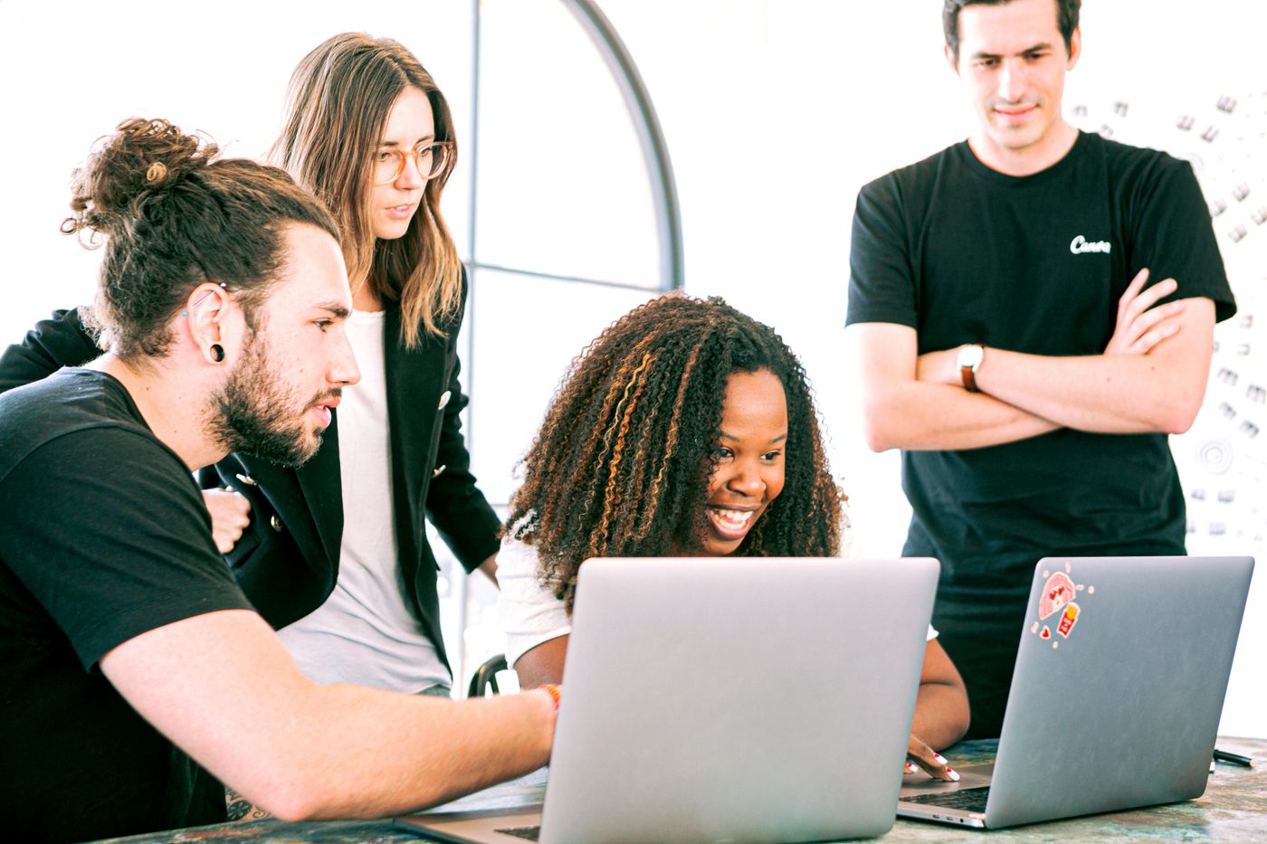 SaaS marketing team working on laptops around a table