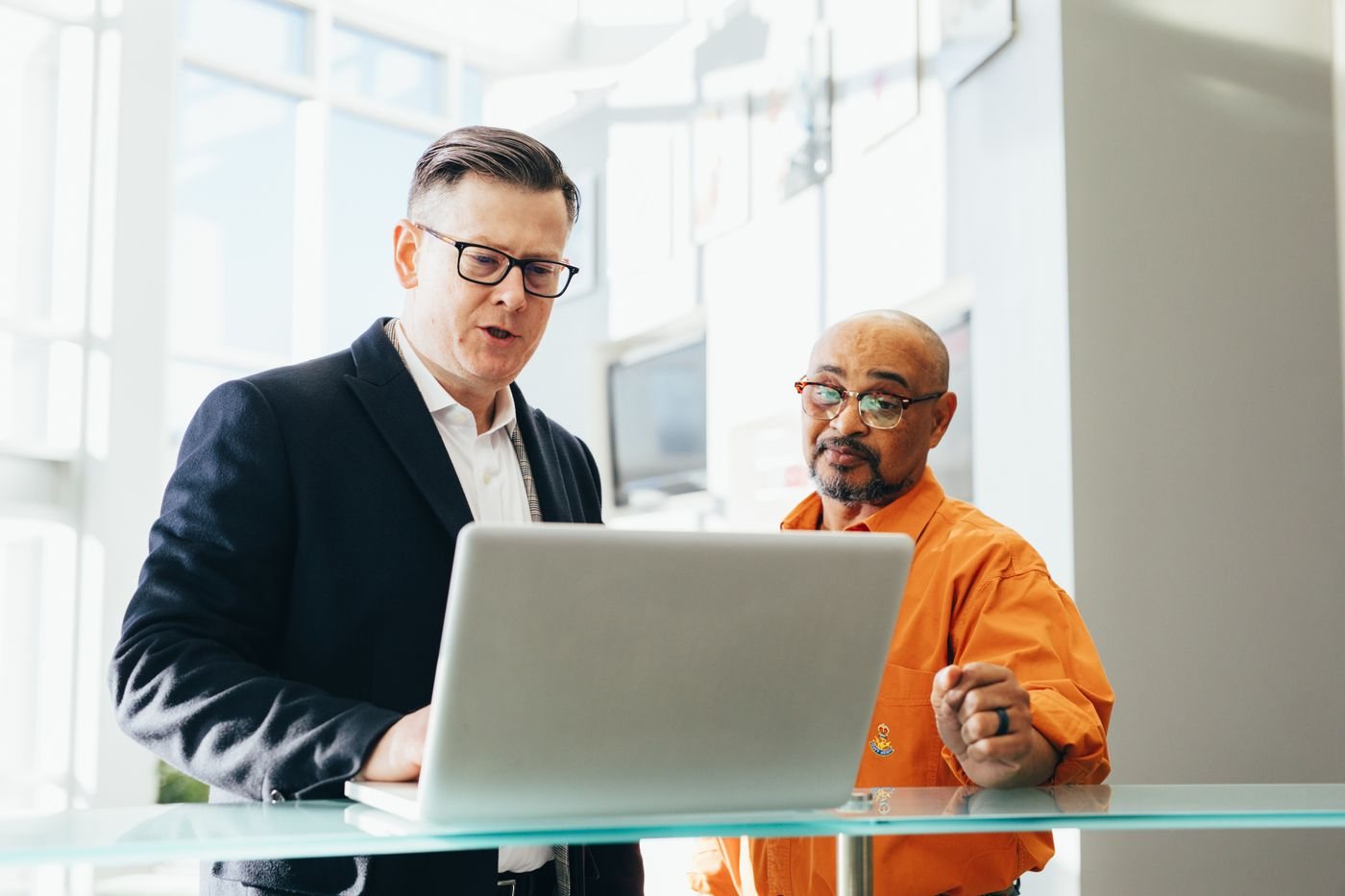 Sales manager coaching a rep through a call review on a laptop