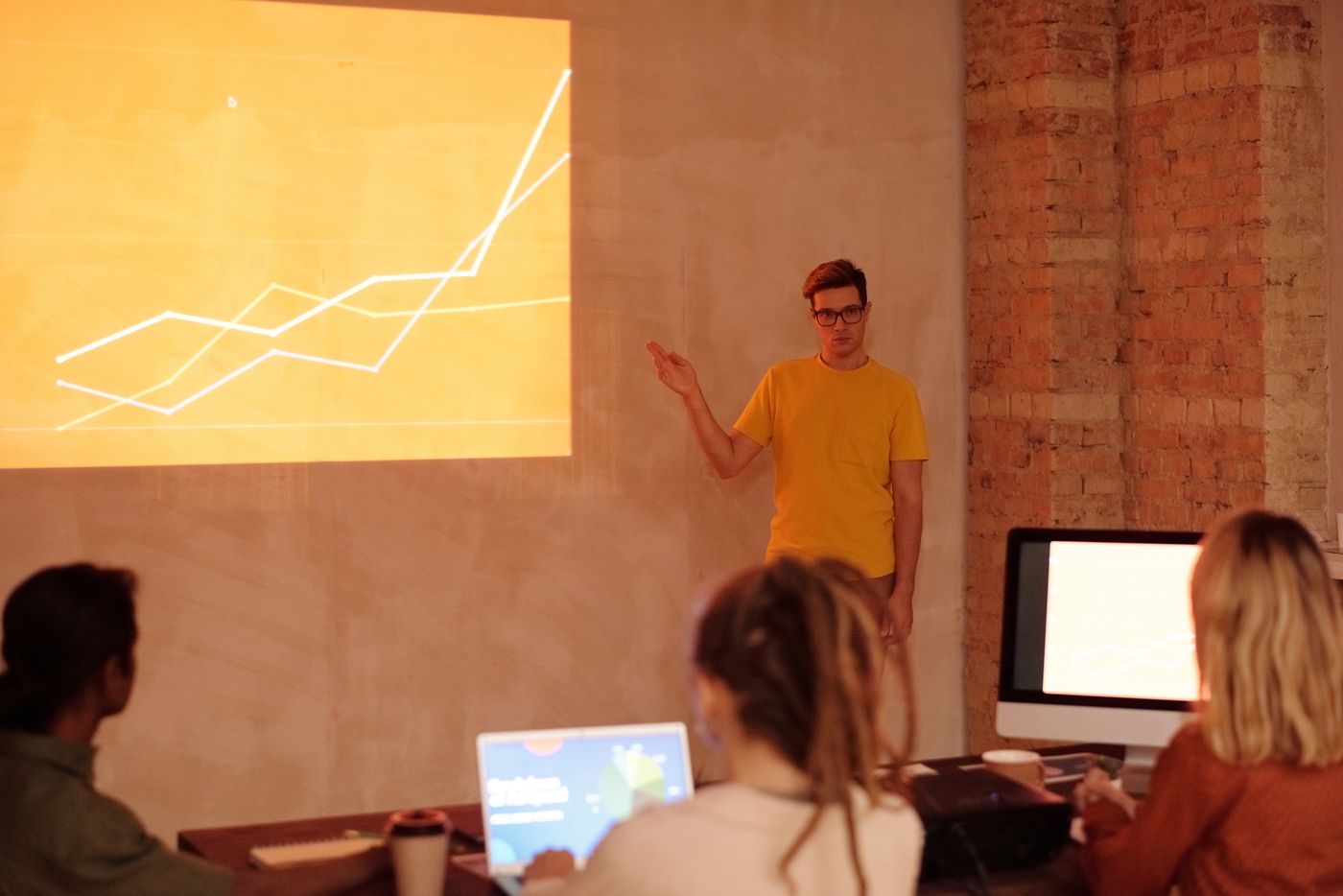 Analyst presenting talent market data on a projected chart to colleagues