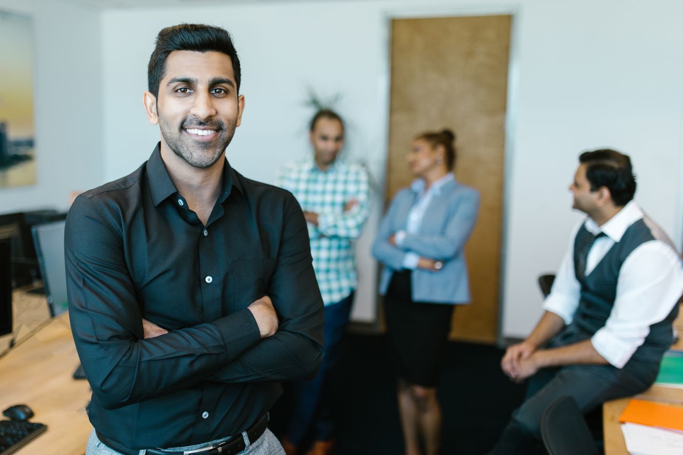 Smiling team lead in front of his engineering team