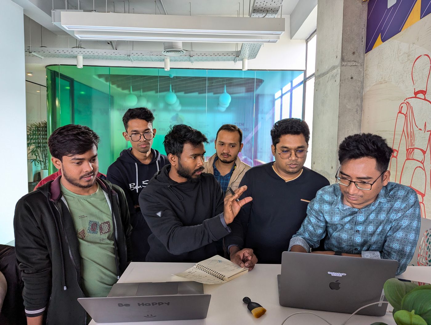 Engineering team gathered around a laptop in a modern office