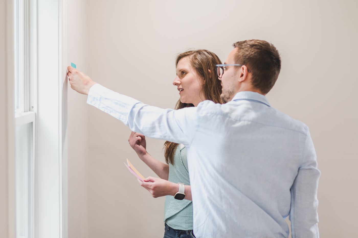 Two colleagues mapping a workflow on a wall