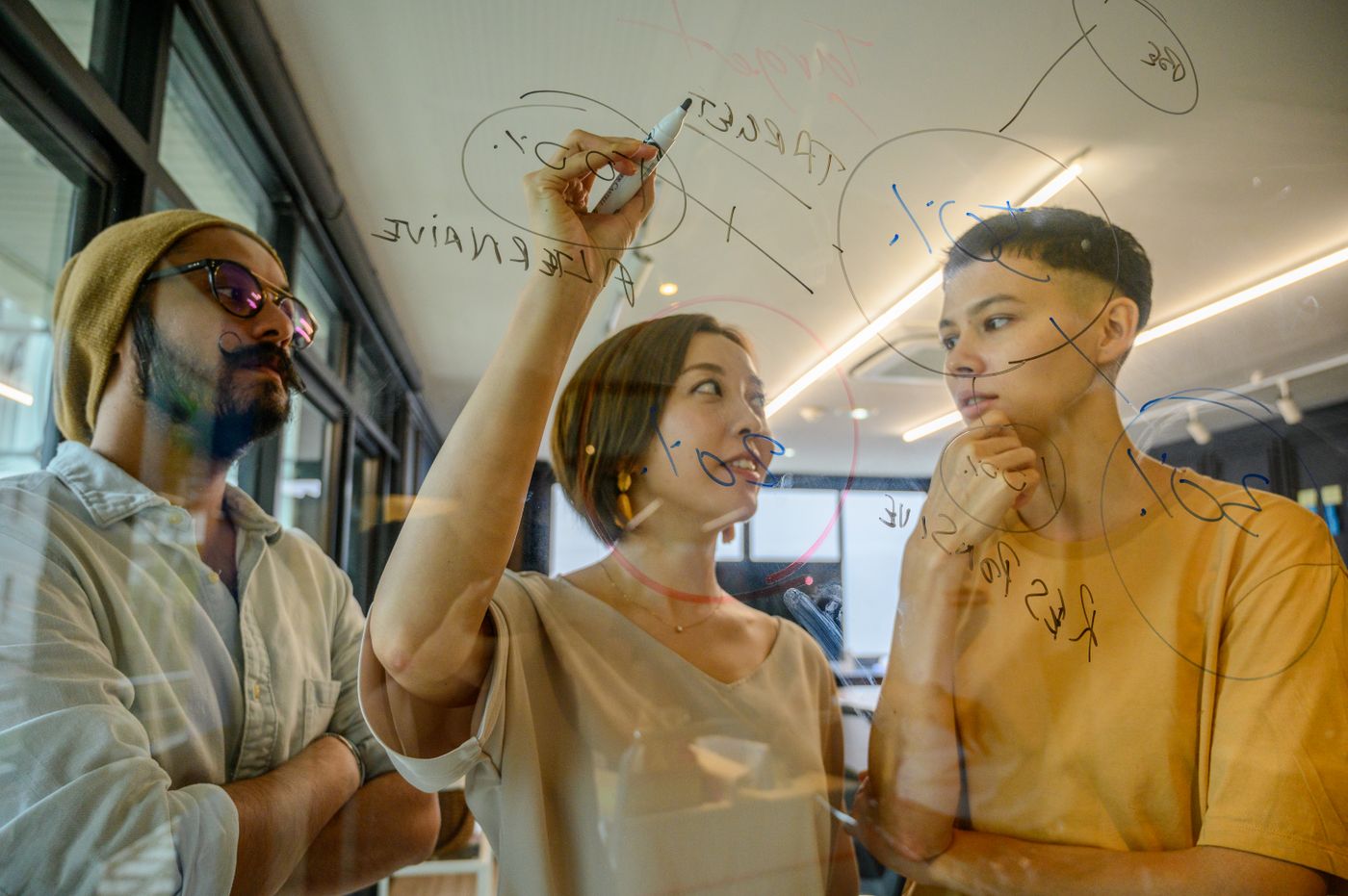 Team sketching a connected process on a whiteboard