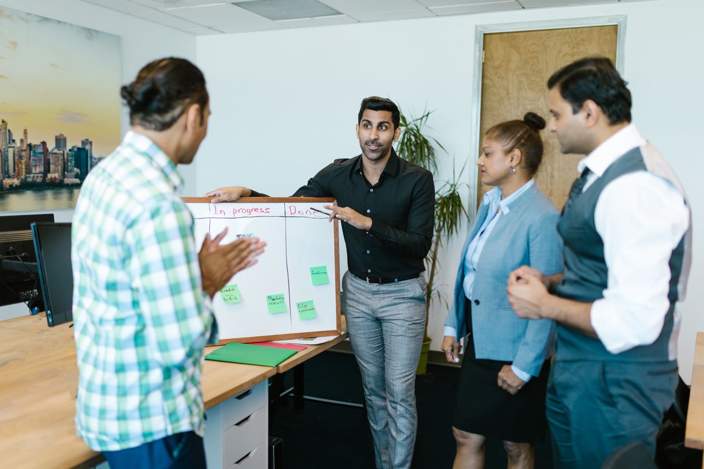 India GCC team discussing a workforce plan pinned to a board