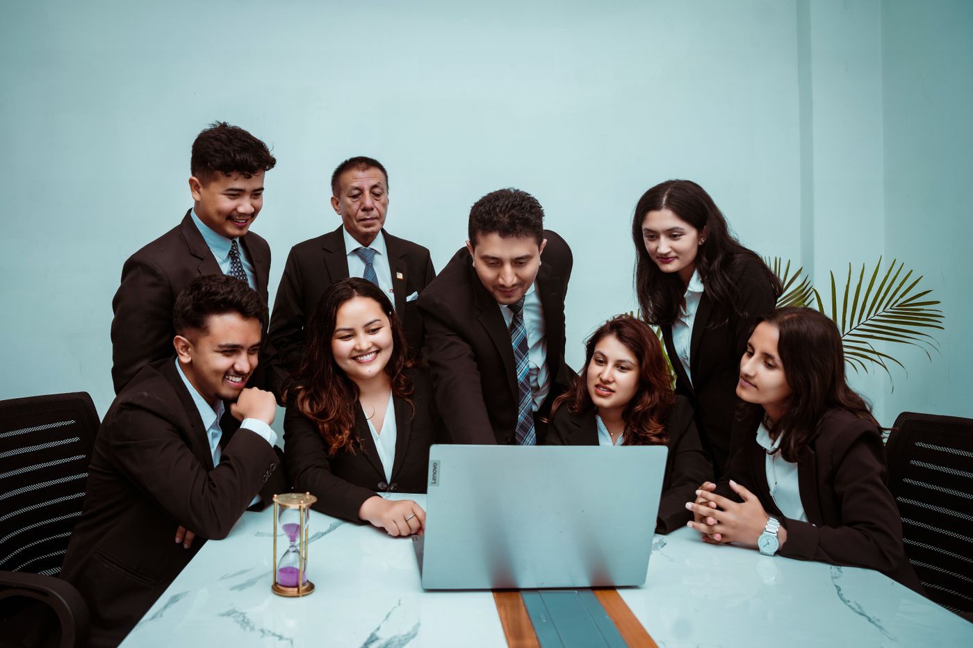 Team of professionals reviewing work together on a laptop