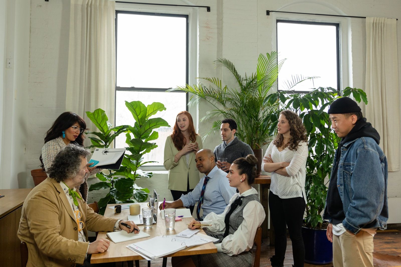 Team meeting around a table in a bright office filled with plants