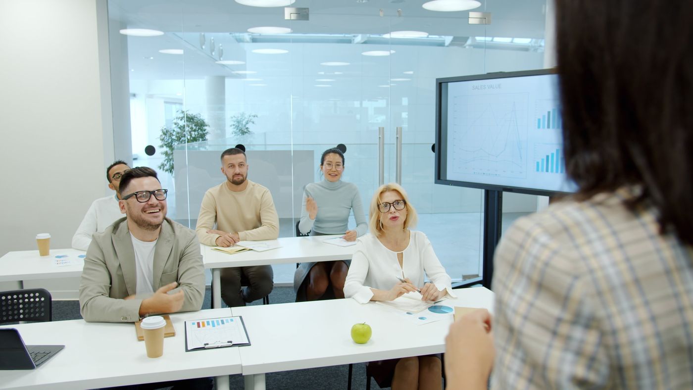 Team in a training room watching a presentation on a screen