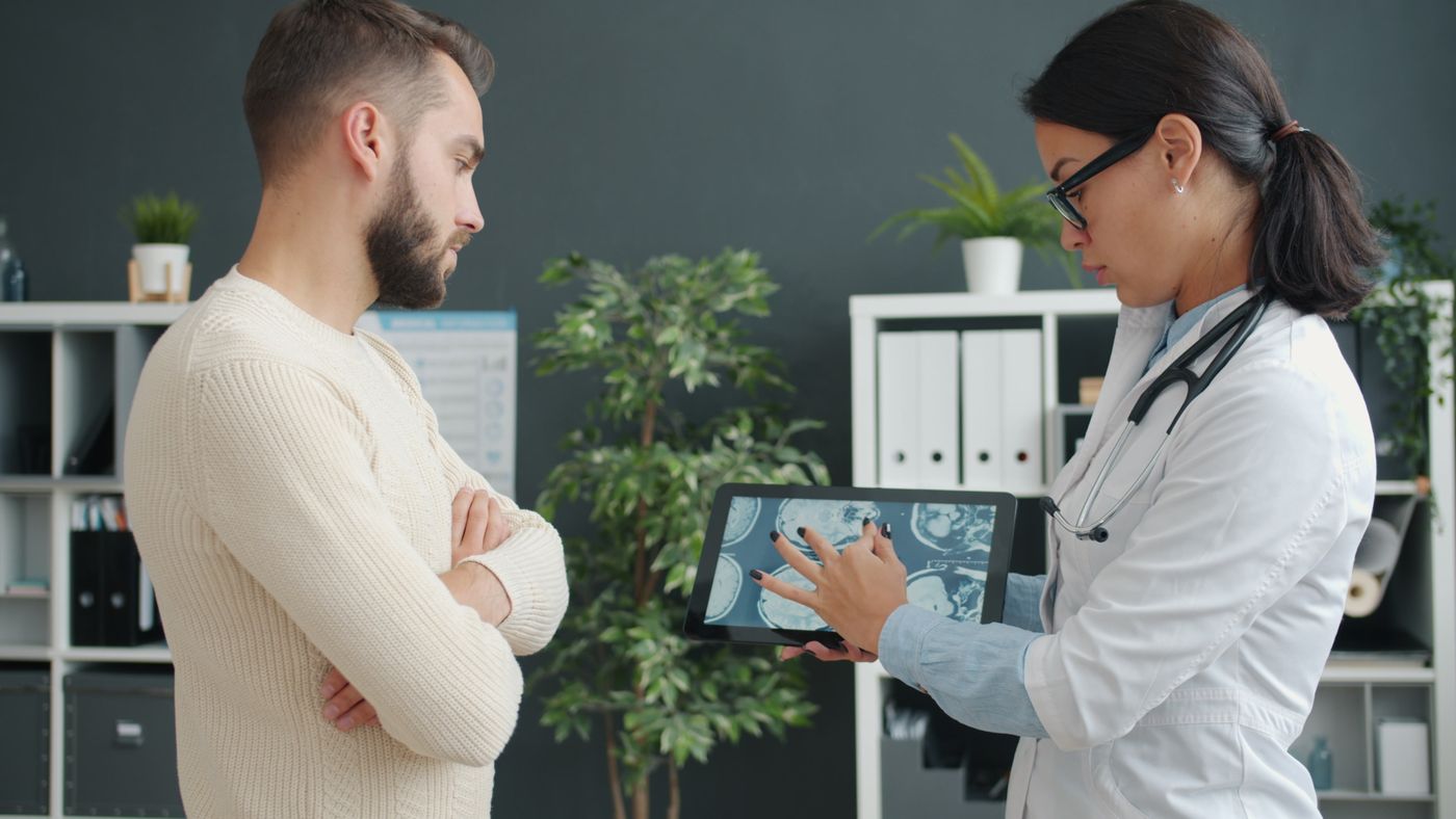 Doctor reviewing a digital health app on a tablet with a patient
