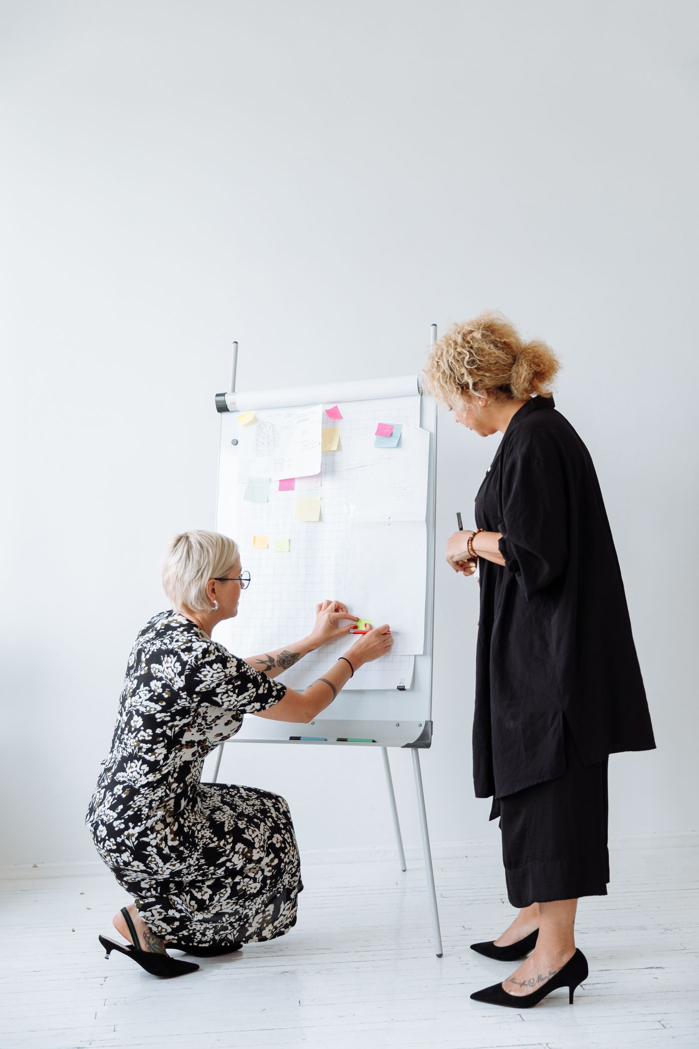 Two colleagues planning a project on a flip chart