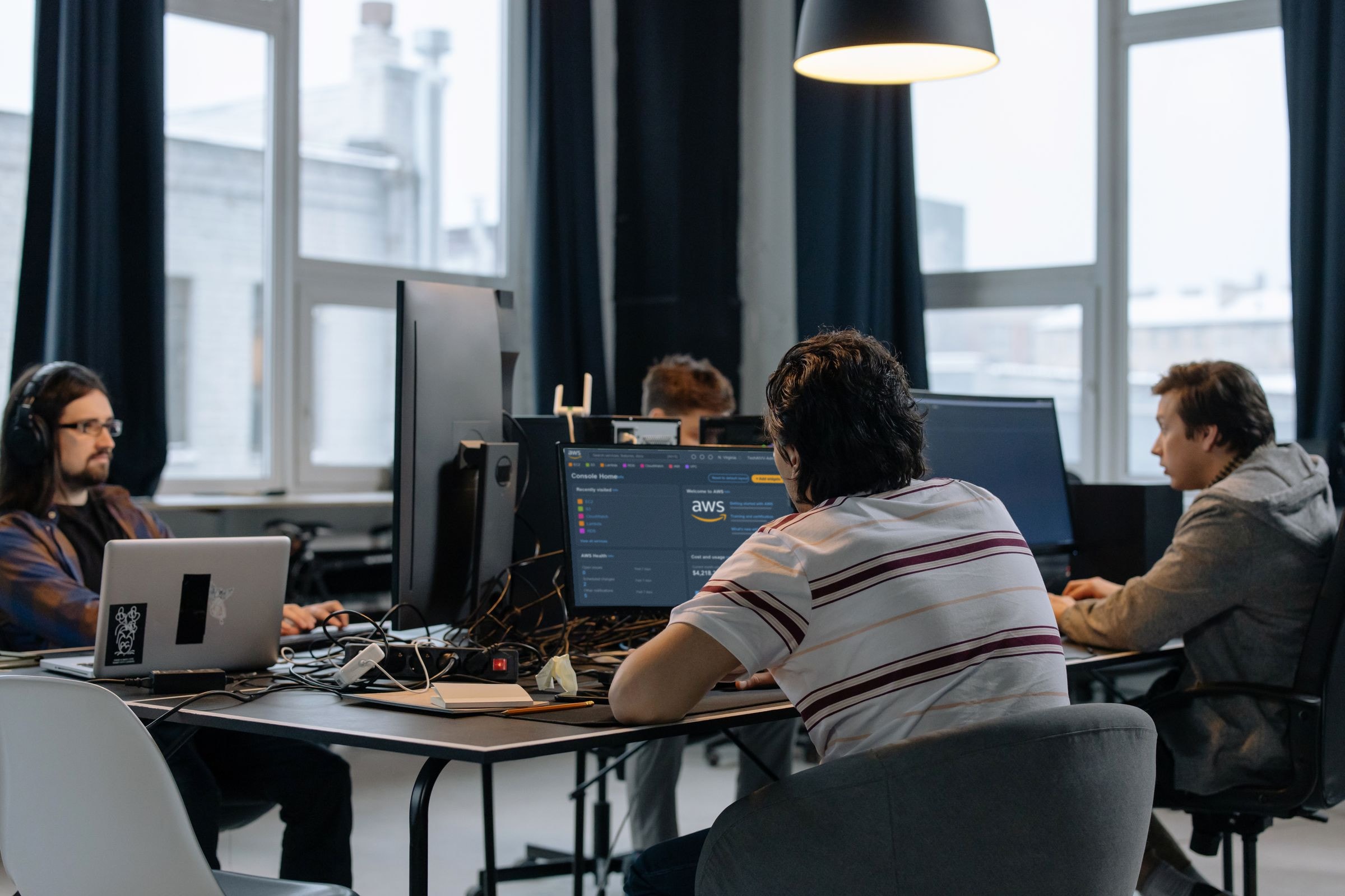 Cloud engineering team working at screens of code in a bright, modern office