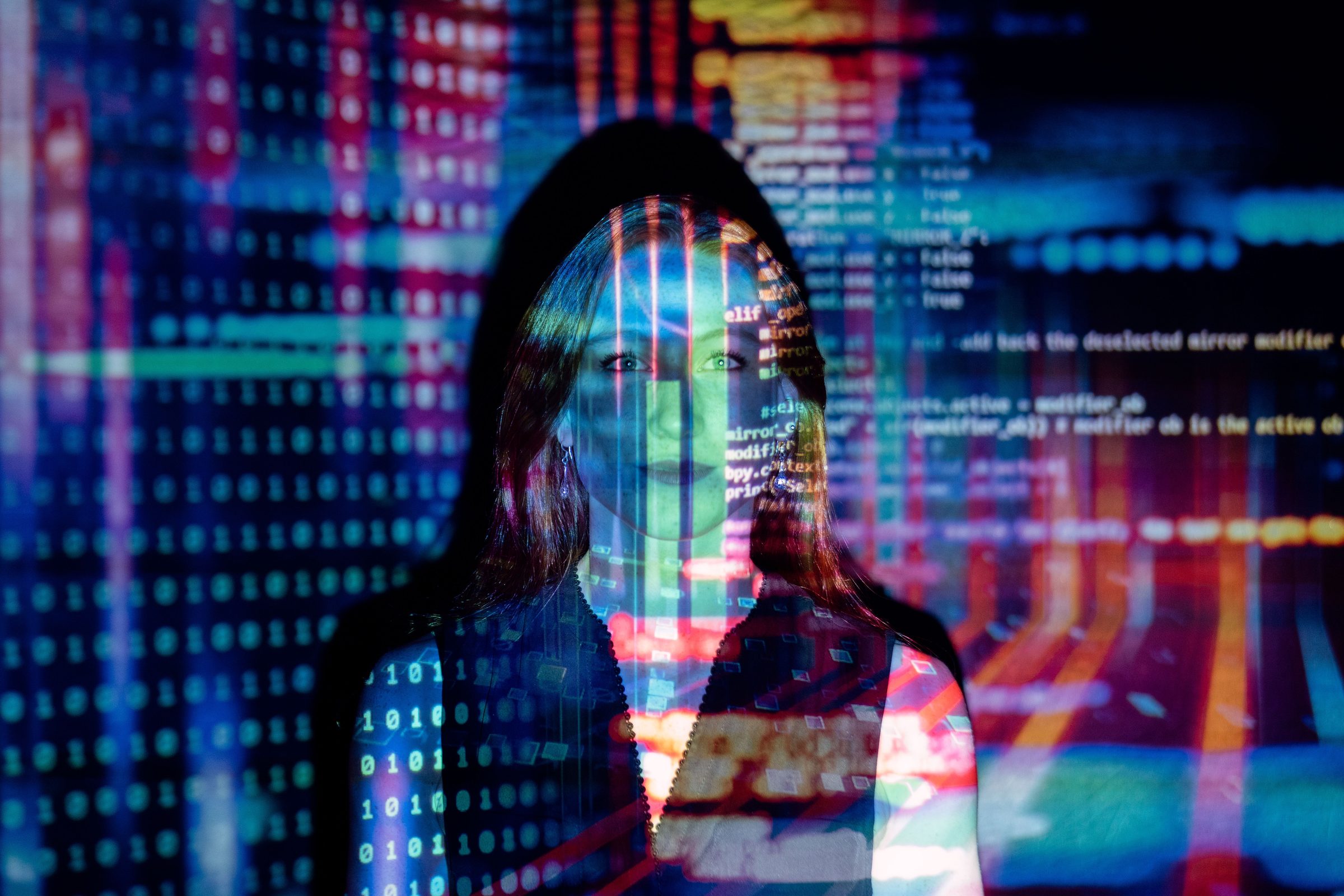 Technology professional with lines of code and data projected across her