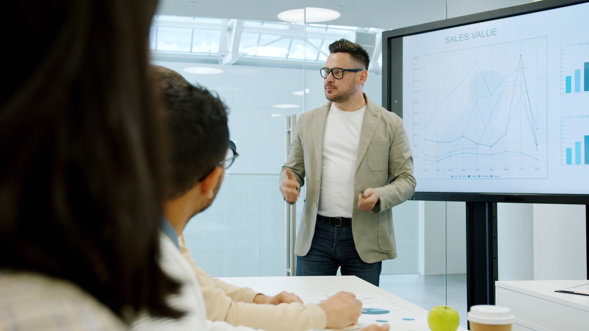 Consultant presenting charts on a screen to colleagues
