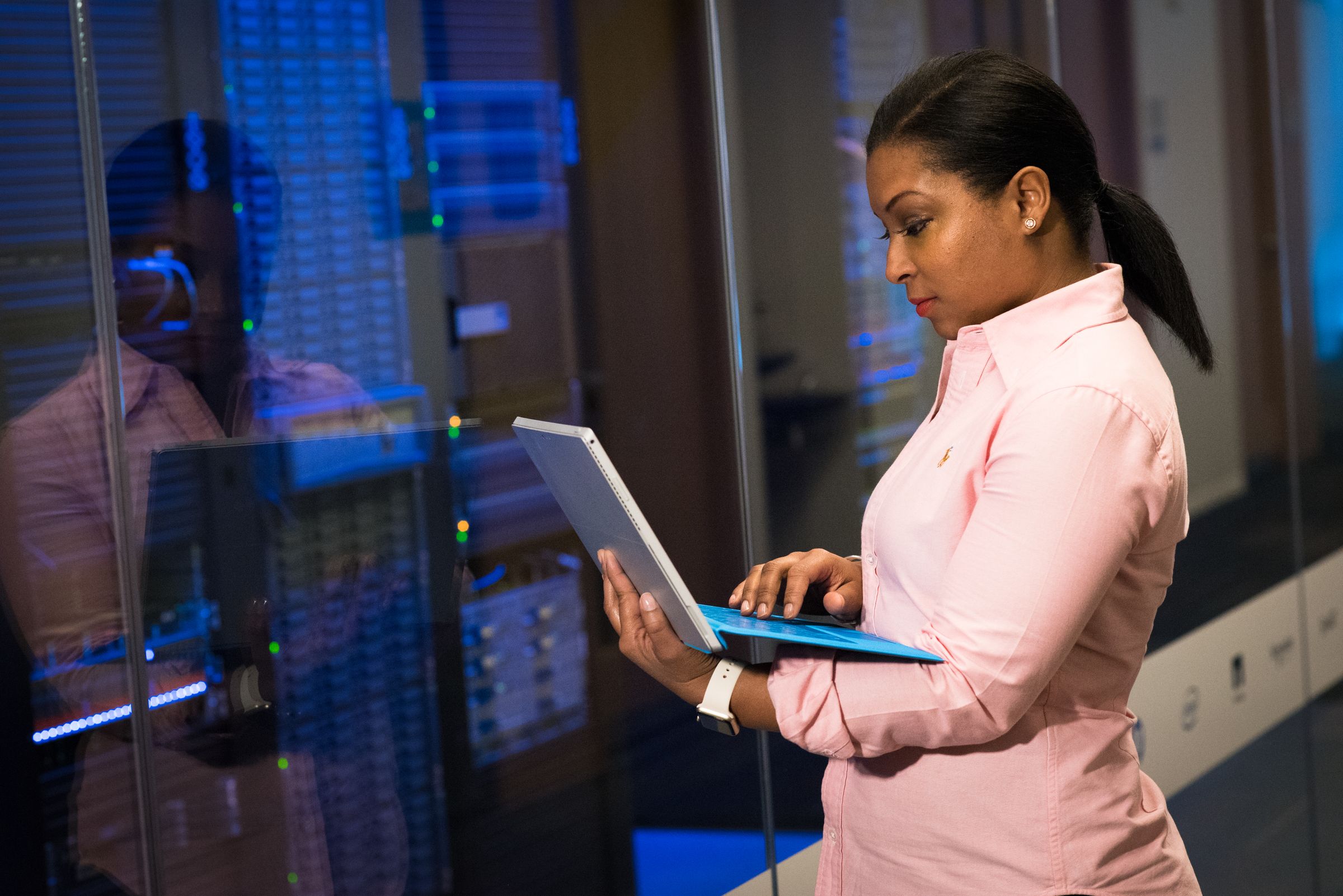 Engineer working on a laptop among data centre systems