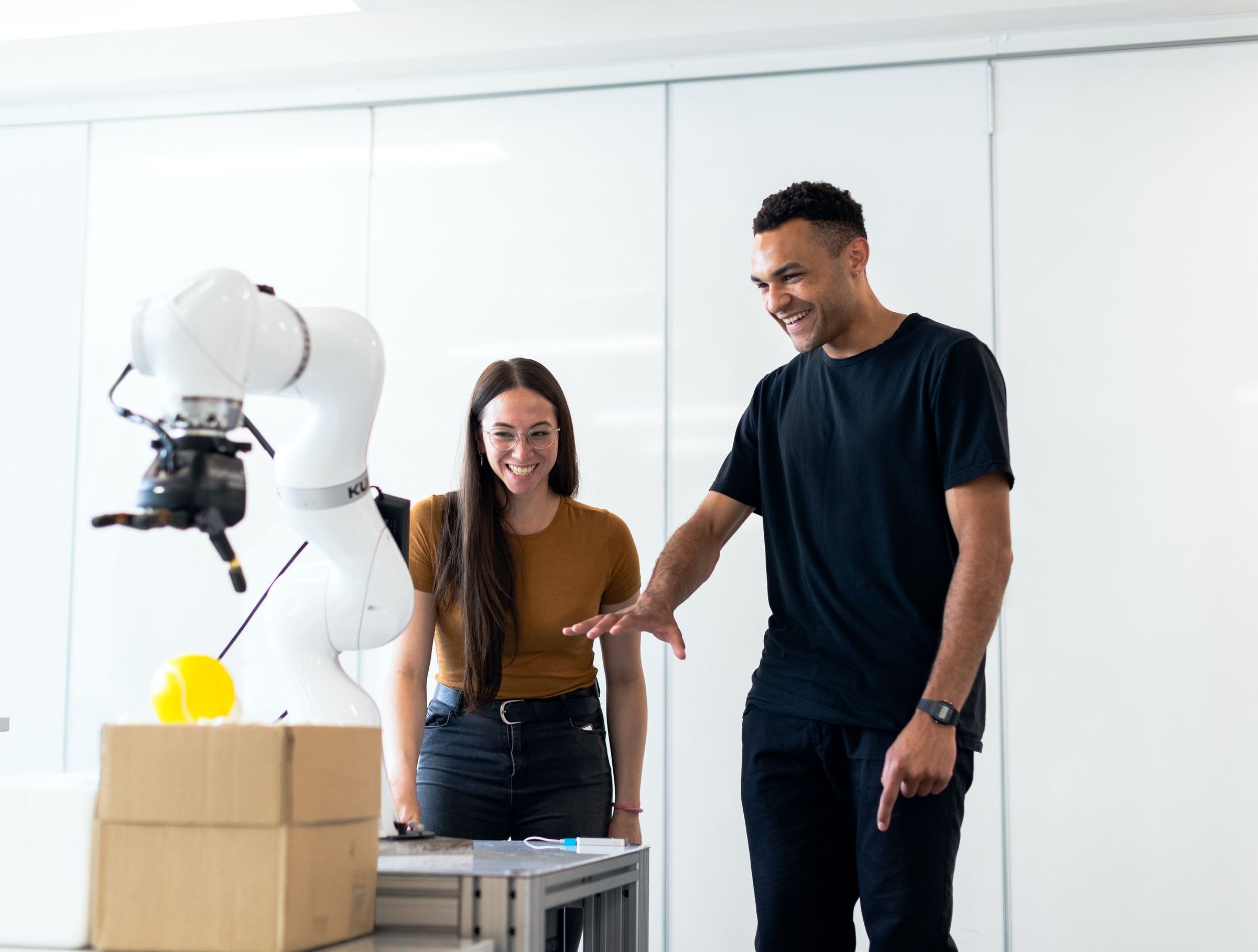 Engineers working beside a collaborative robot in a lab