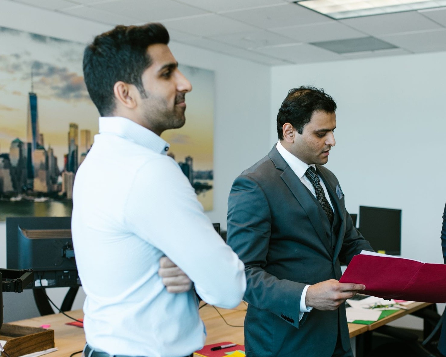 Two senior leaders reviewing a candidate shortlist together in an office
