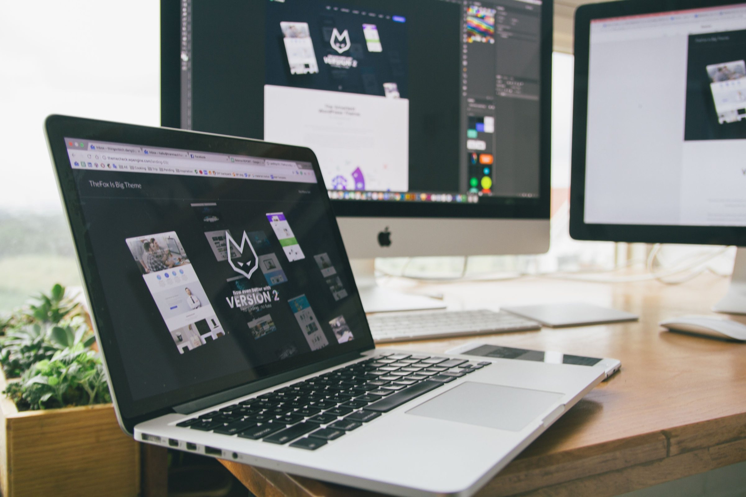 Designer’s workstation with product screens open on a laptop and a monitor