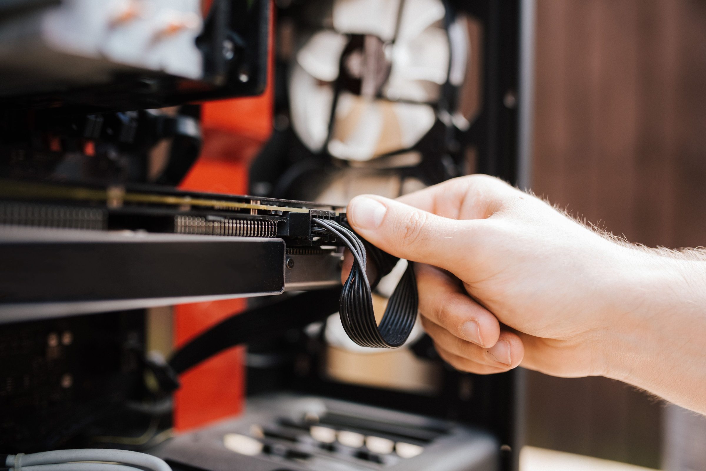 Cloud migration engineering: a hand connecting a cable into a rack-mounted server