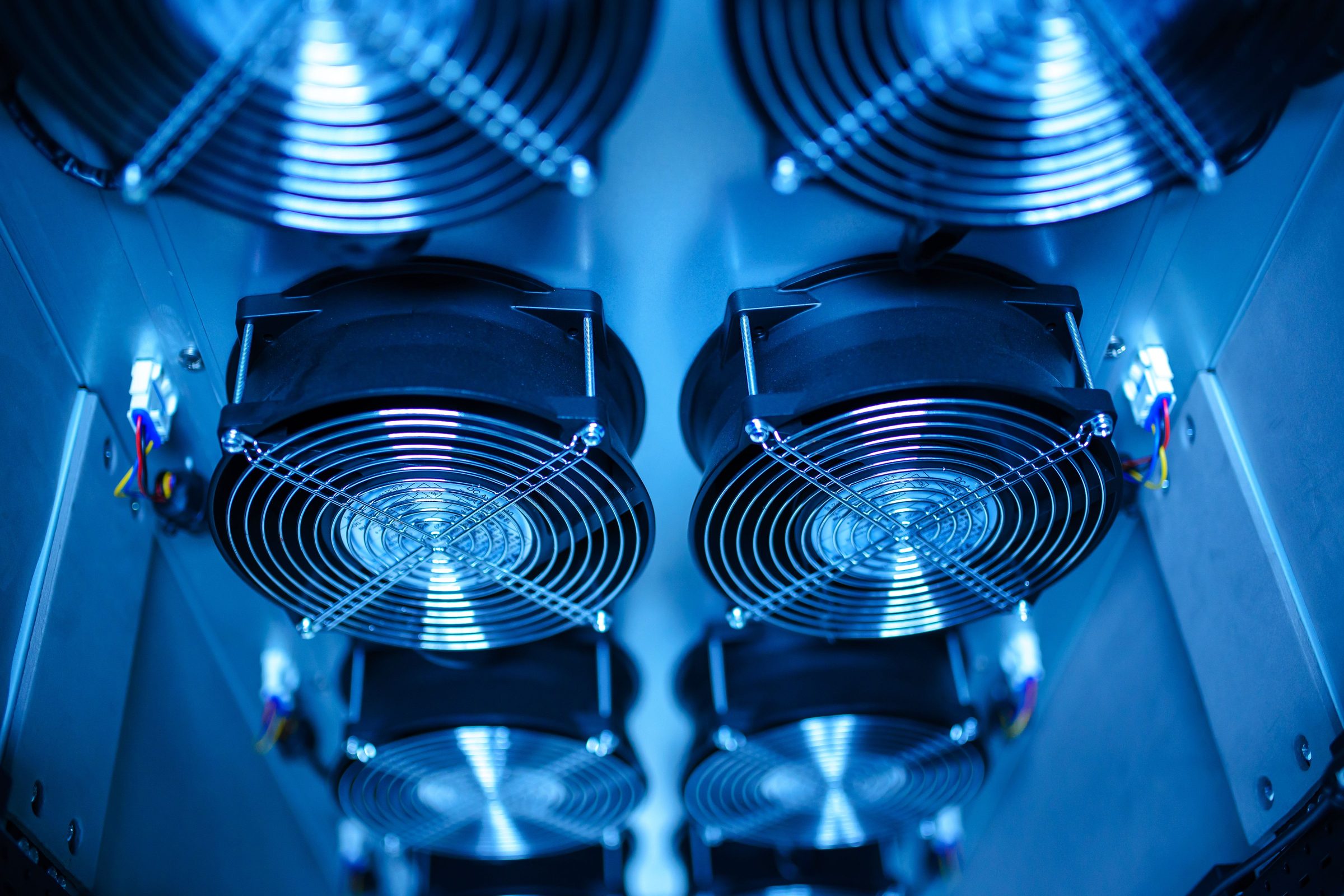 Cloud infrastructure: server cooling fans lit blue inside a data centre enclosure