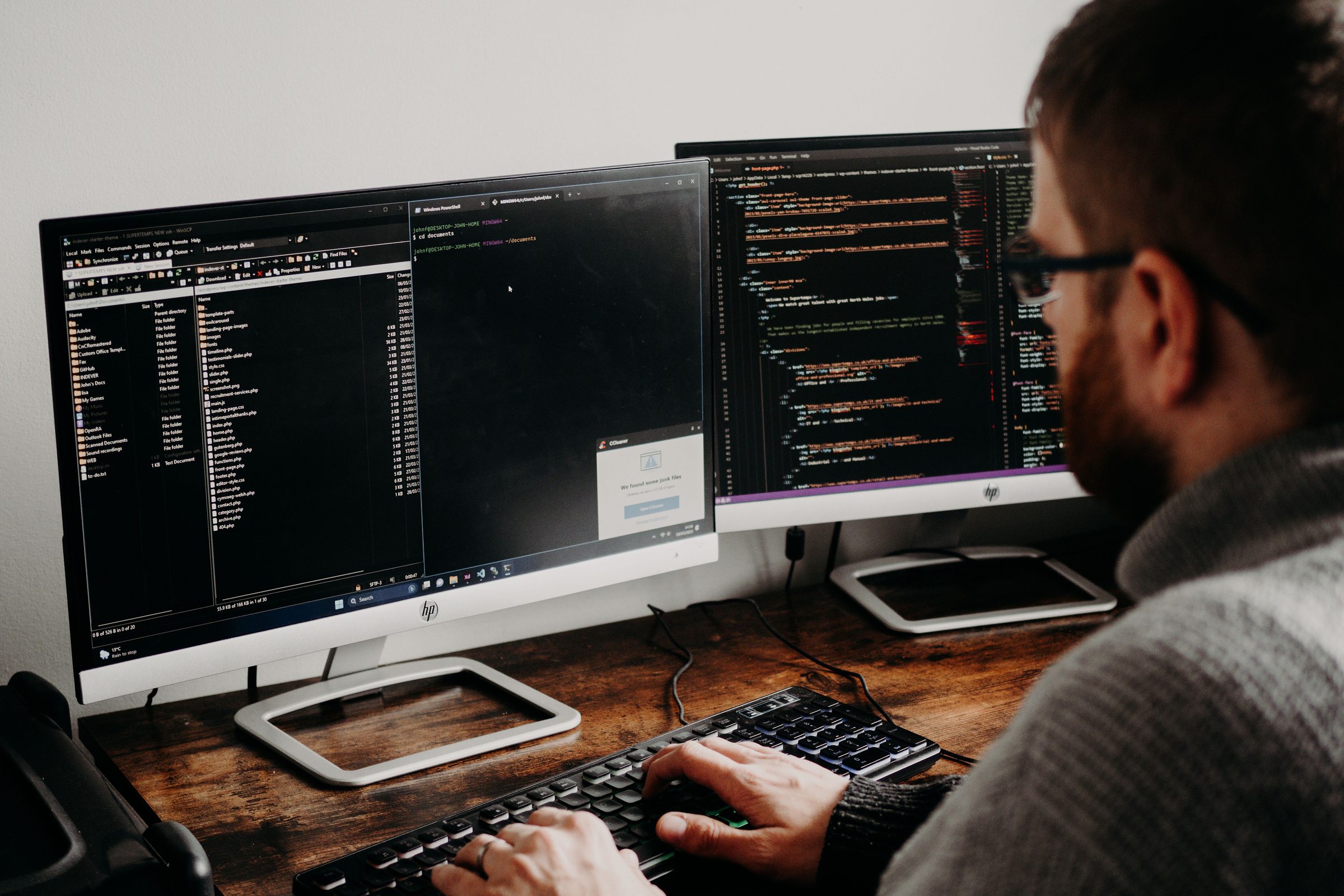 Developer writing code across two monitors