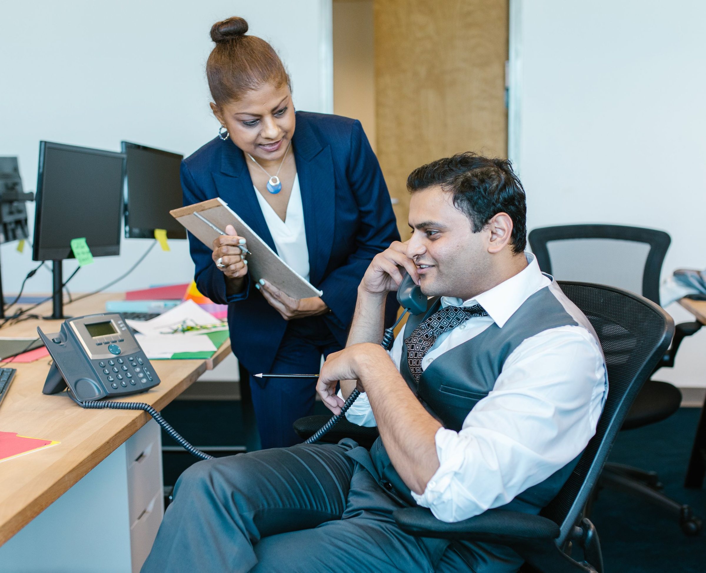 Sales rep on a prospect call while his manager reviews target accounts on a tablet