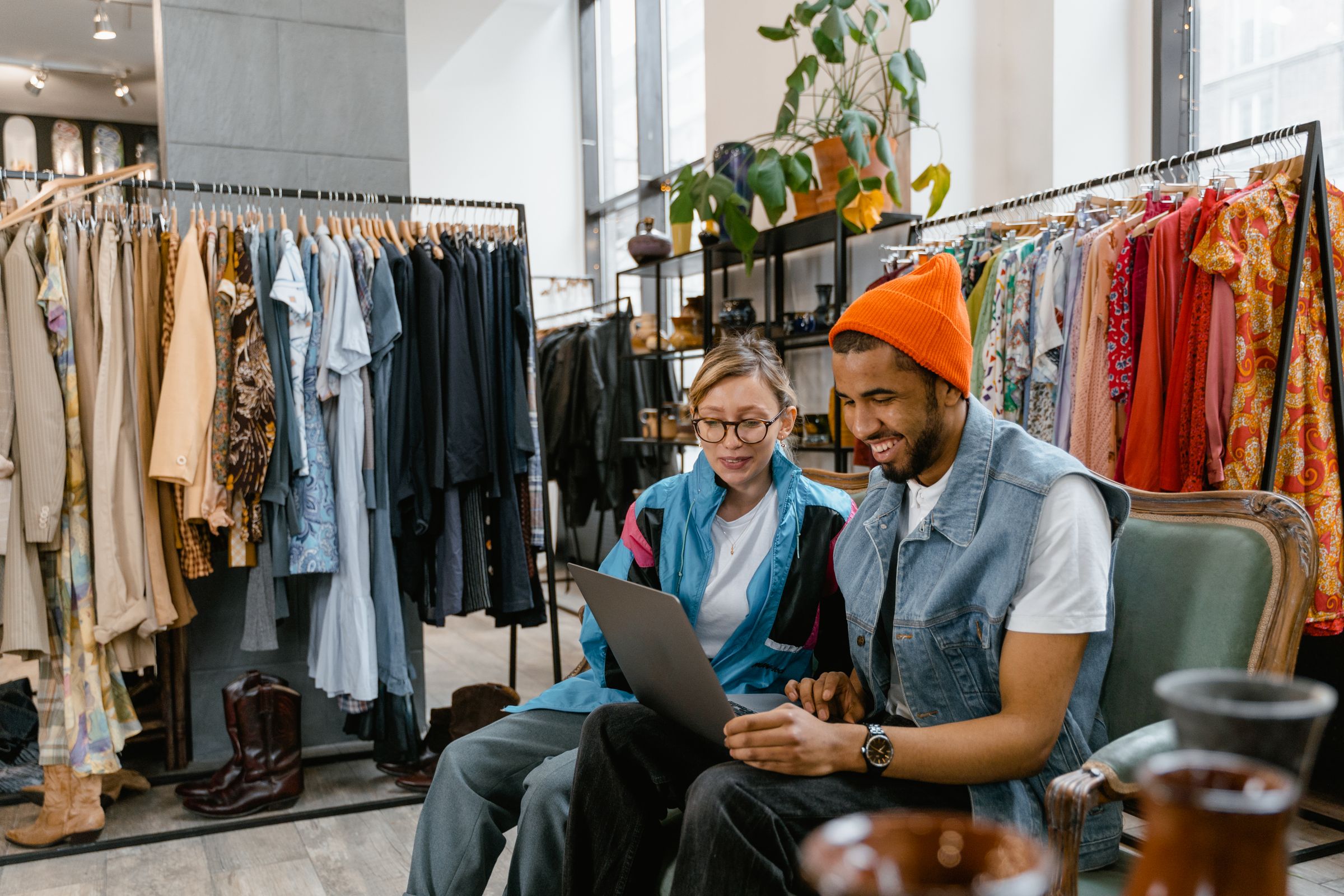 Two colleagues working on a laptop in a clothing store